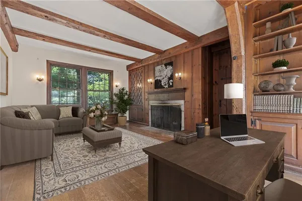 a living room with furniture a fireplace and a large window