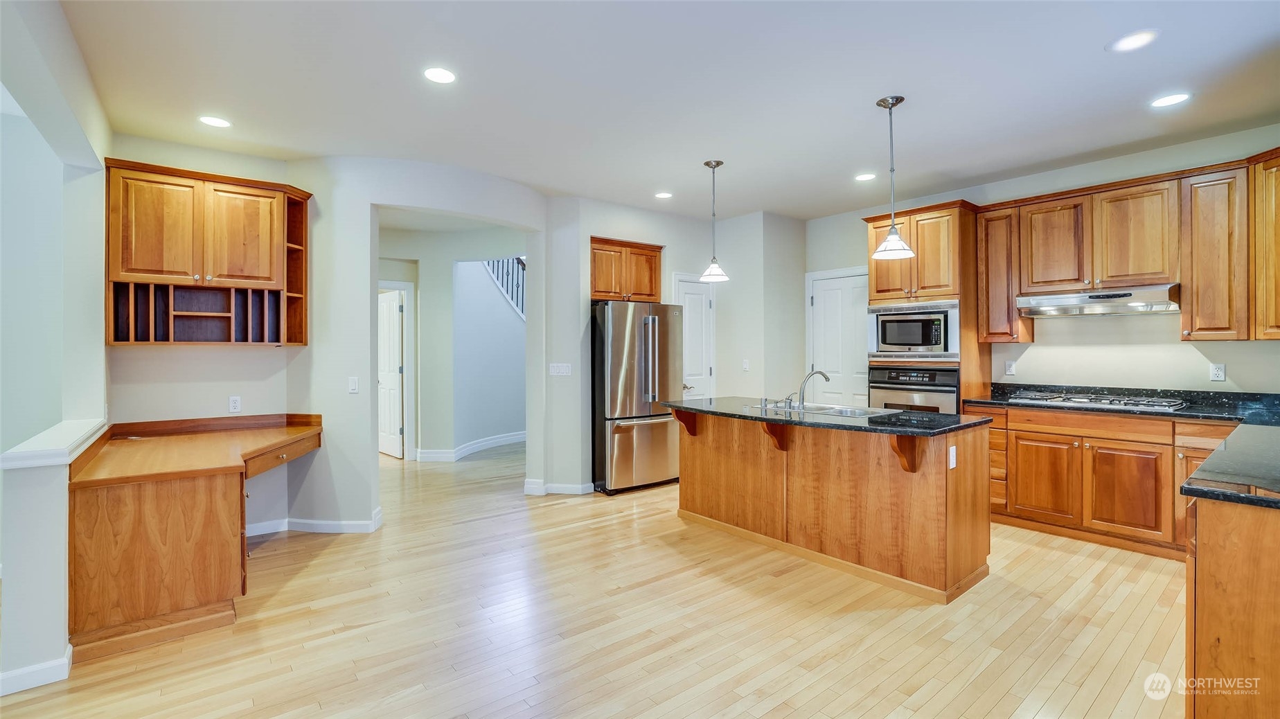 16601 Southeast 165th Way Renton, WA 98058 - Photo 4 of 33 a kitchen with stainless steel appliances granite countertop a refrigerator a sink dishwasher a stove and a dining table with wooden floor