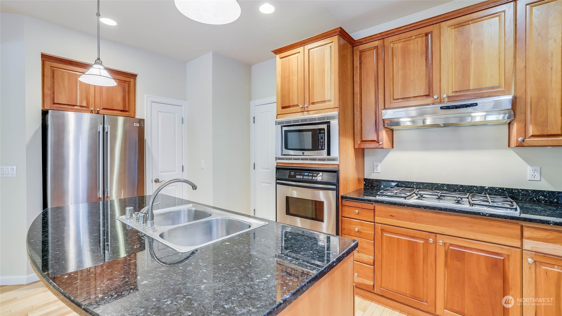 16601 Southeast 165th Way Renton, WA 98058 - Photo 7 of 33 a kitchen with stainless steel appliances granite countertop a refrigerator a stove and white cabinets with wooden floor