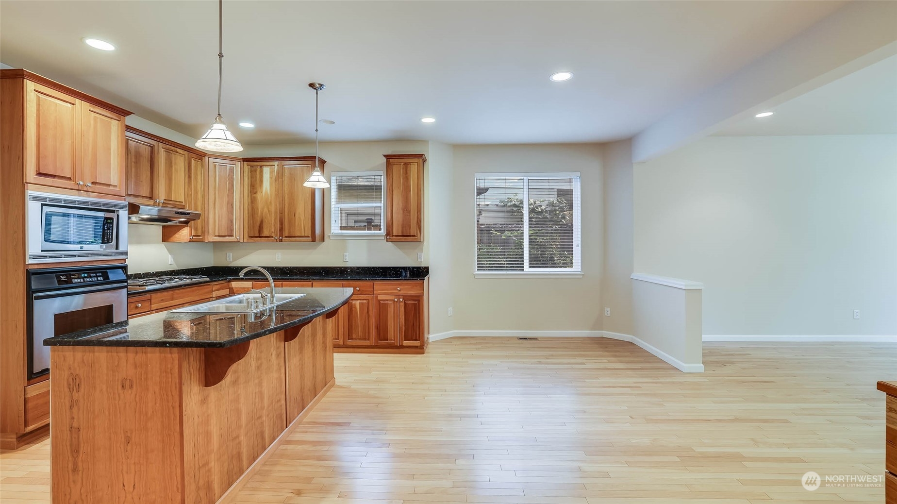 16601 Southeast 165th Way Renton, WA 98058 - Photo 8 of 33 a kitchen with stainless steel appliances granite countertop a sink a stove and a wooden floors
