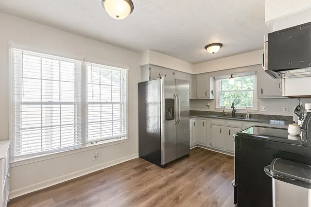 a kitchen with stainless steel appliances granite countertop a stove top oven a sink and dishwasher with wooden floor