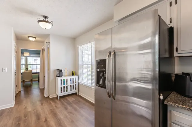 a kitchen with granite countertop a sink window and cabinets