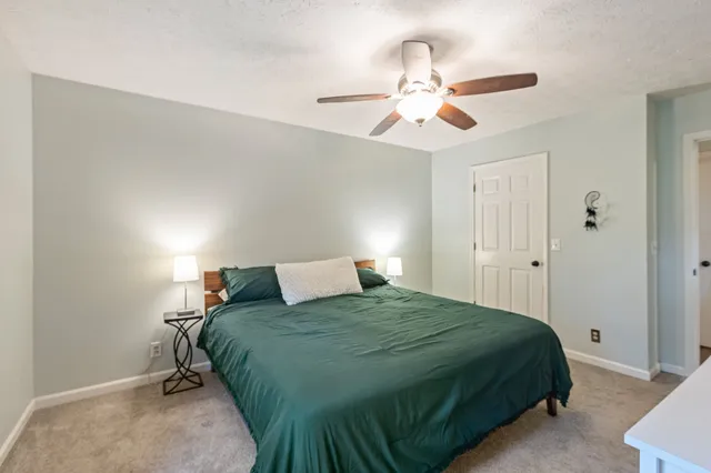 a bedroom with a large bed and a chandelier
