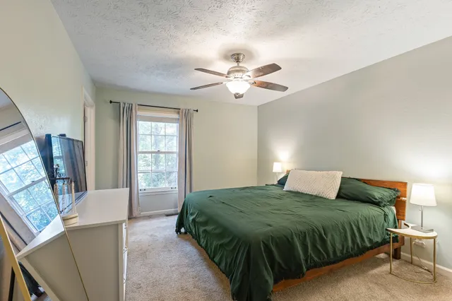 a bedroom with a large bed and a flat screen tv