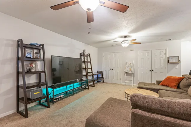 a living room with furniture and a ceiling fan