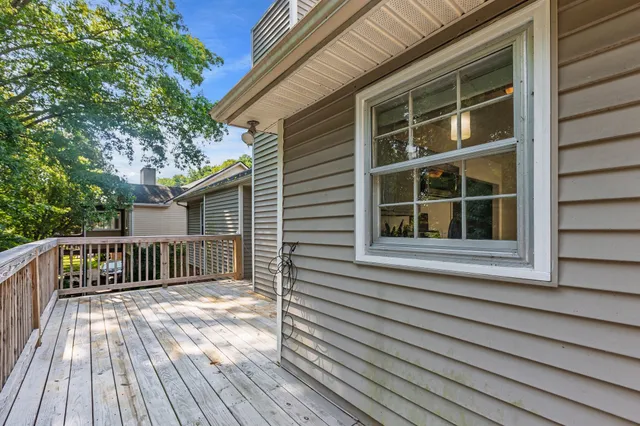 a view of a balcony with wooden floor and fence
