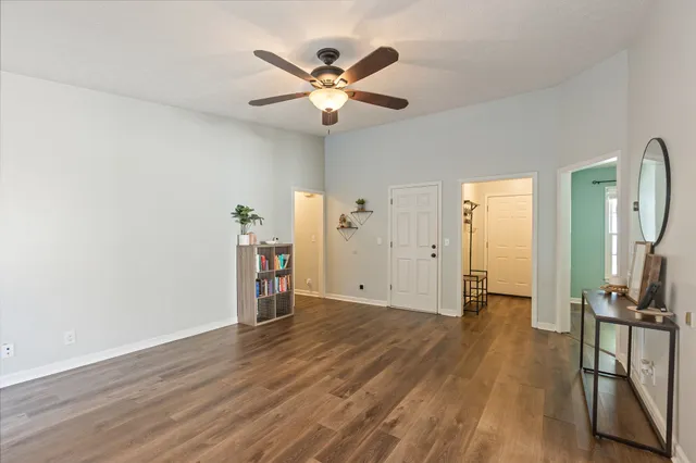 a view of empty room with wooden floor and window