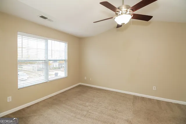 an empty room with a window and a fan