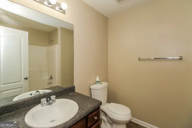 a bathroom with a sink a toilet and a mirror