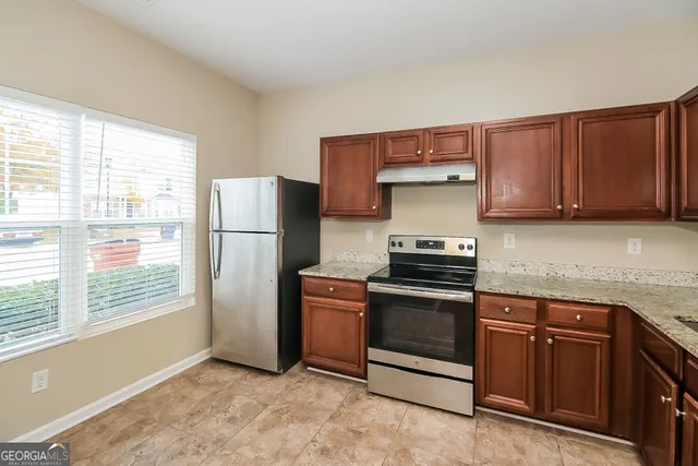 a kitchen with stainless steel appliances granite countertop a refrigerator stove and sink