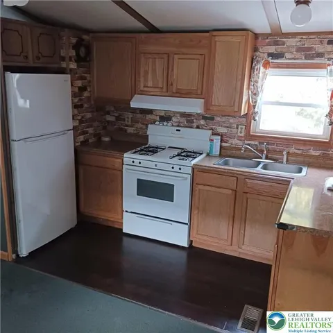 a kitchen with a stove a sink and a refrigerator