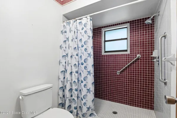 a bathroom with a toilet and a shower