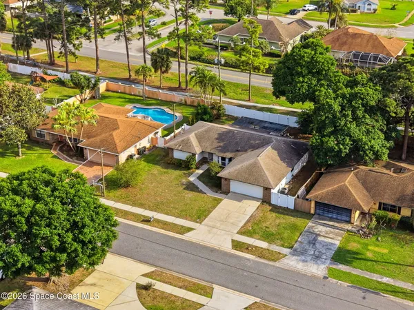 an aerial view of a house with swimming pool and patio