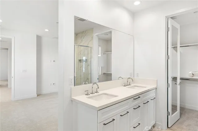 a bathroom with a sink shower and a mirror