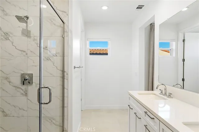 a bathroom with a granite countertop sink a shower and a mirror