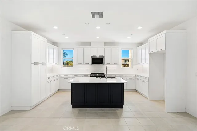 a kitchen with stainless steel appliances granite countertop a stove top oven and refrigerator