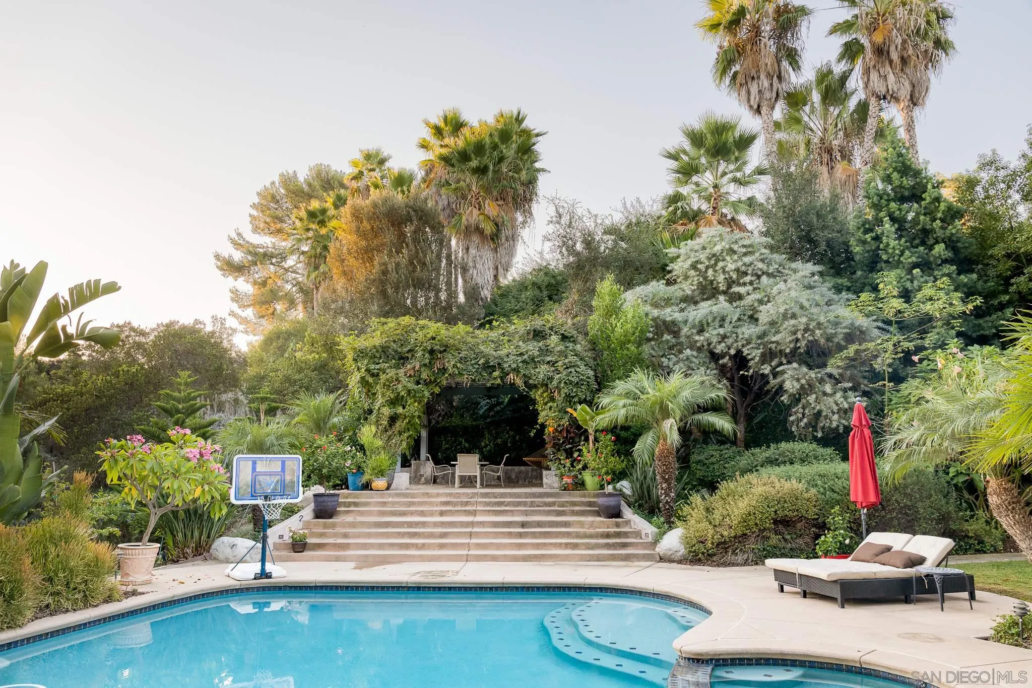 16319 Martincoit Road Poway, CA 92064 - Photo 27 of 29 a view of a white house with a yard and potted plants
