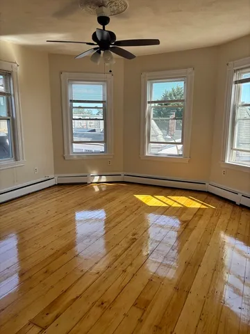 a view of a room with wooden floor and windows