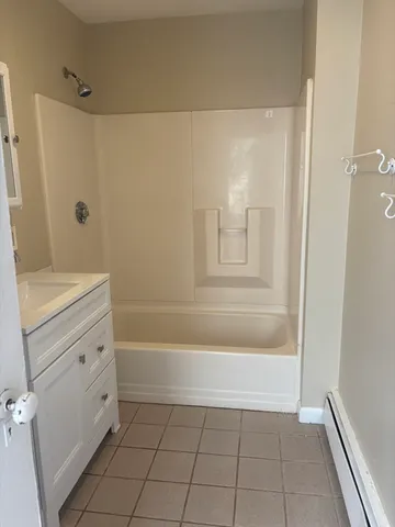a bathroom with a tub shower and a sink