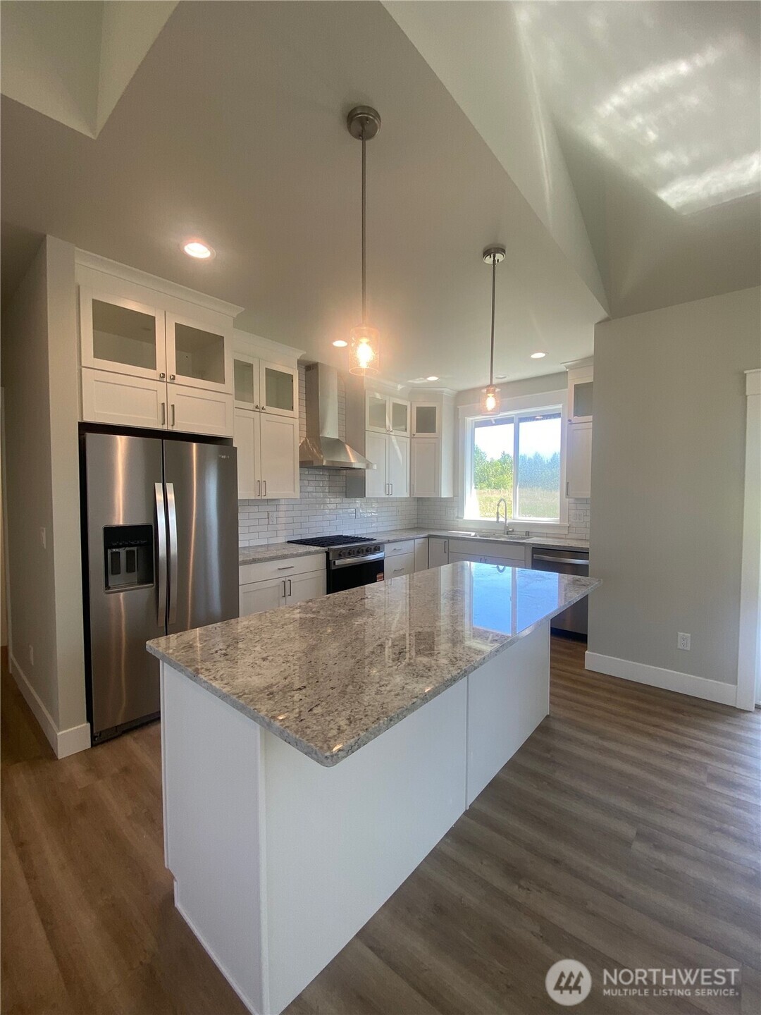 5953 (lot 64) Ranch Loop Ferndale, WA 98248 - Photo 7 of 38 a large kitchen with kitchen island a large counter top a sink and stainless steel appliances
