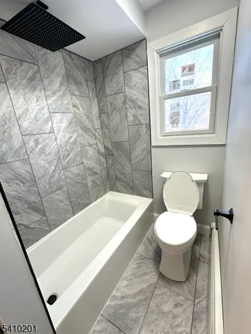a bath tub sitting next to a white toilet and a shower