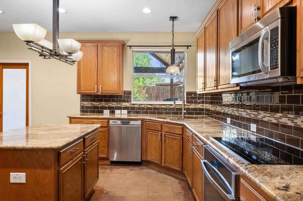 1305 Liverpool Lane Mansfield, TX 76063 - Photo 25 of 40 The kitchen features wood cabinetry, granite countertops, a tile backsplash, and stainless steel appliances