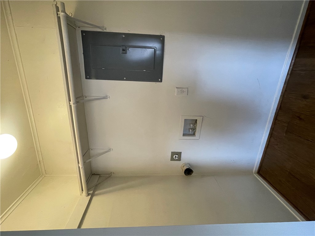 807 East 31st Street, Unit 8 Bryan, TX 77803 - Photo 5 of 7 Laundry room with washer hookup, dark wood-style flooring, hookup for an electric dryer, electric panel, and baseboards