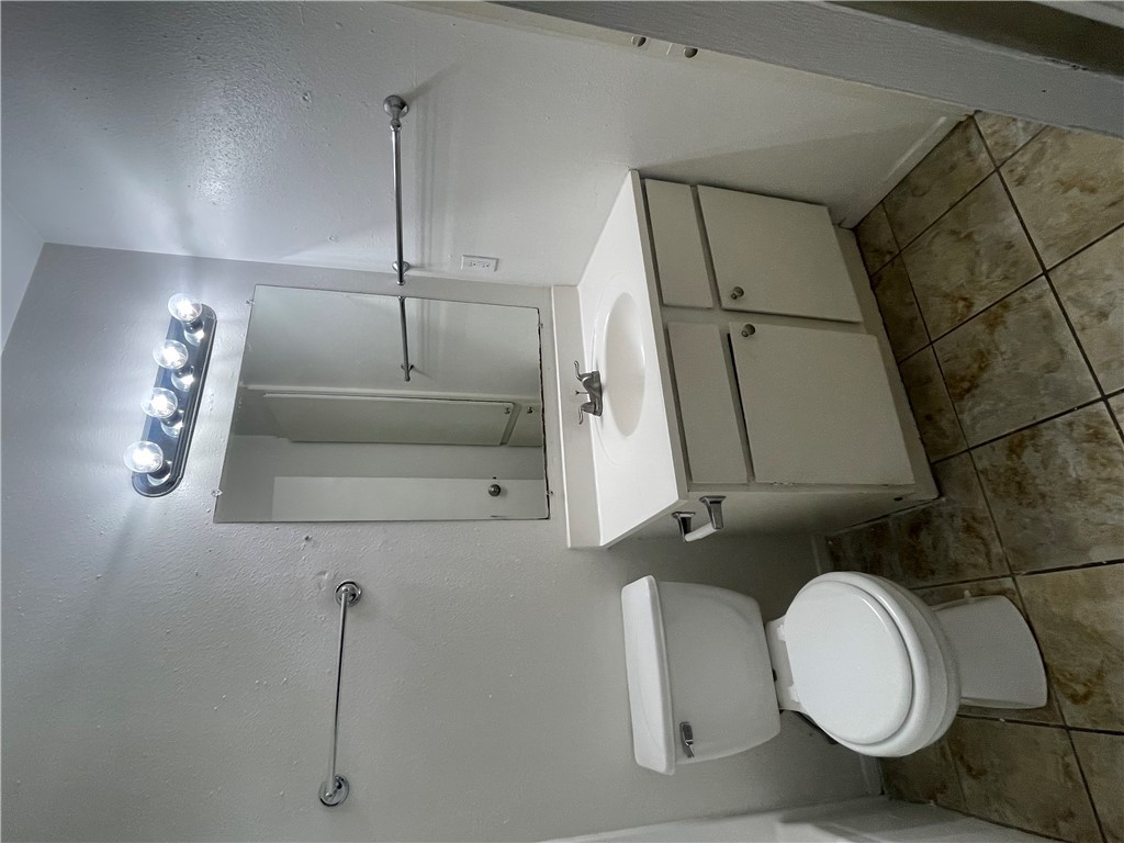 807 East 31st Street, Unit 8 Bryan, TX 77803 - Photo 6 of 7 a bathroom with a sink mirror and toilet