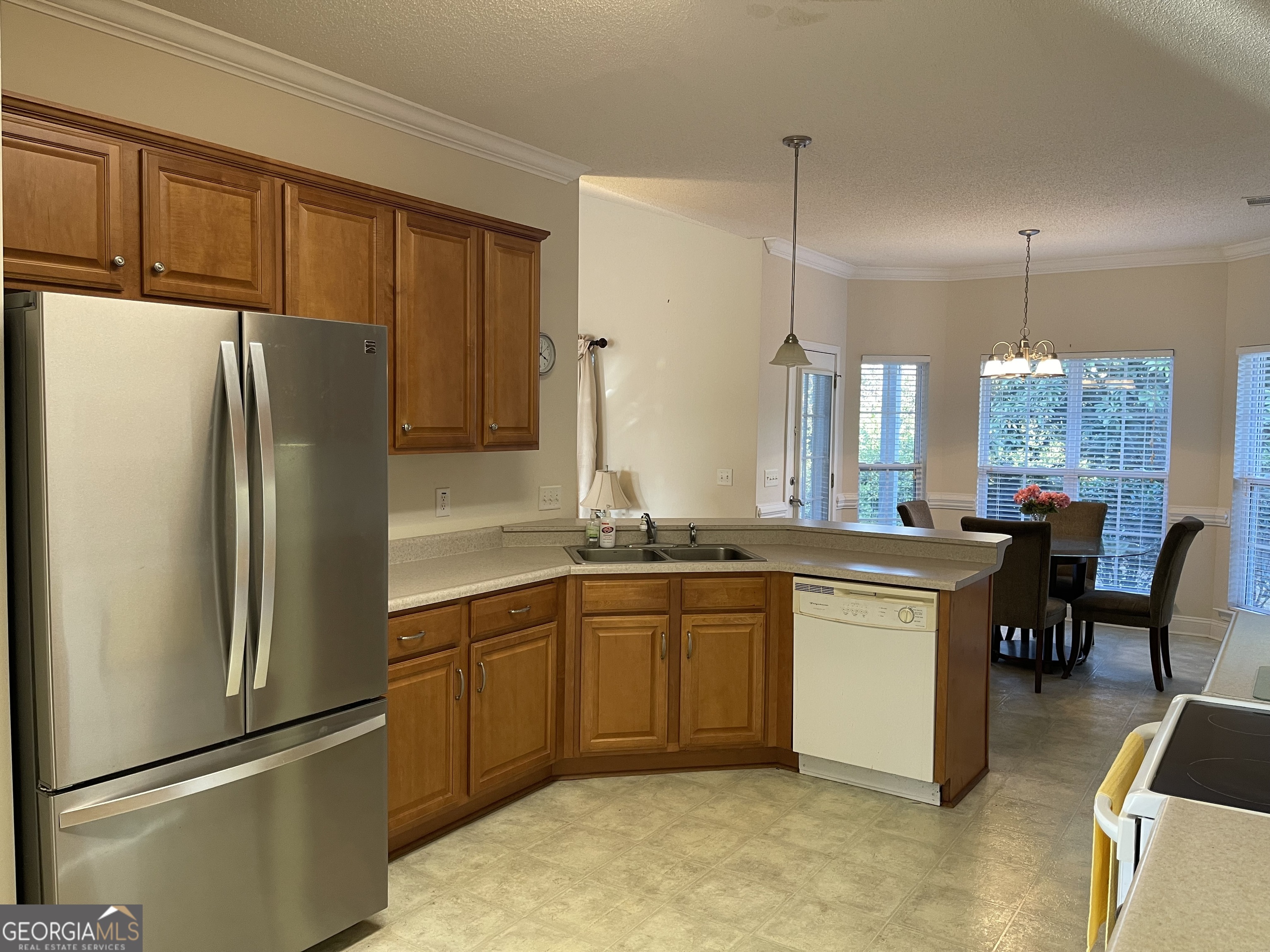 137 Blue Ridge Drive Statesboro, GA 30458 - Photo 6 of 26 a kitchen with stainless steel appliances granite countertop a refrigerator a sink a stove a dining table and chairs