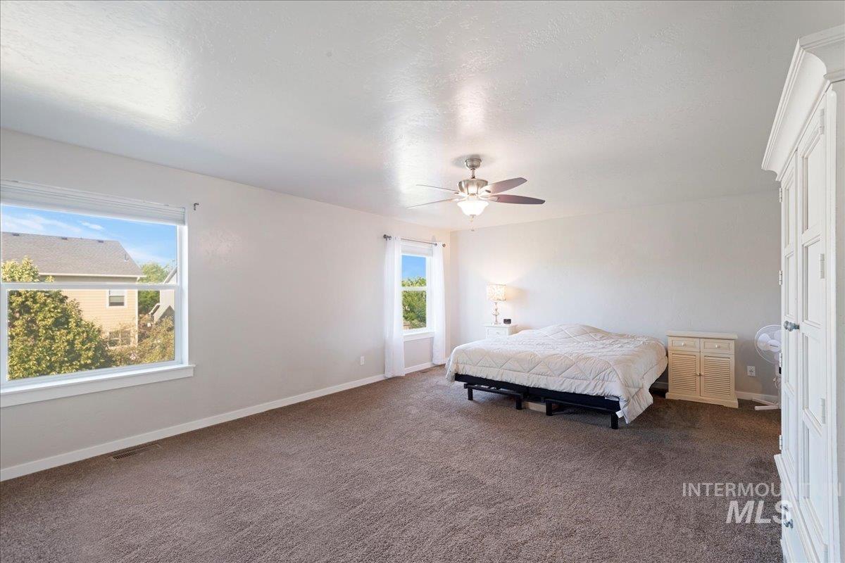 401 East Joshua Tree Drive Meridian, ID 83646 - Photo 13 of 32 Carpeted bedroom with baseboards and a ceiling fan