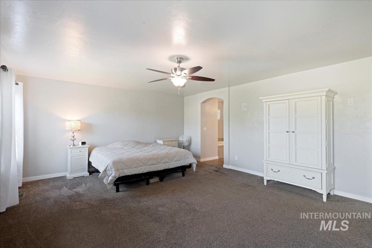 401 East Joshua Tree Drive Meridian, ID 83646 - Photo 14 of 32 Carpeted bedroom featuring arched walkways and a ceiling fan