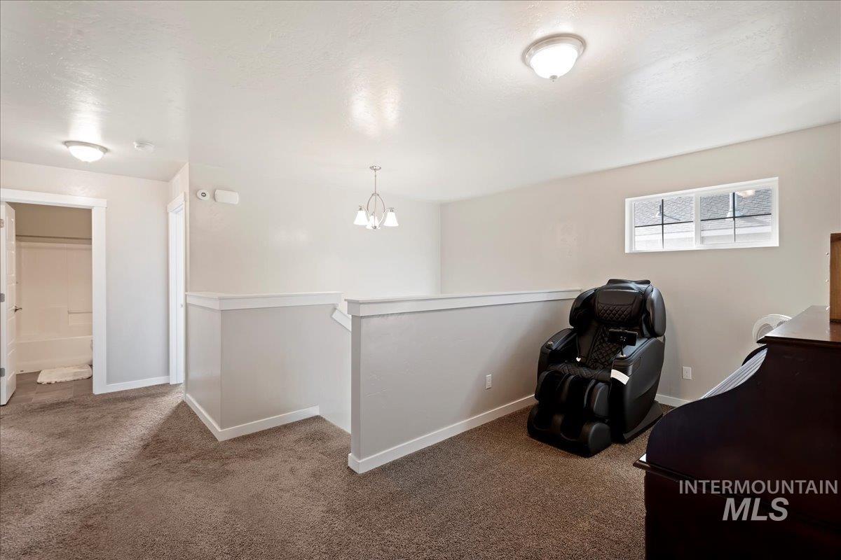 401 East Joshua Tree Drive Meridian, ID 83646 - Photo 23 of 32 Sitting room with carpet floors, an upstairs landing, and a chandelier