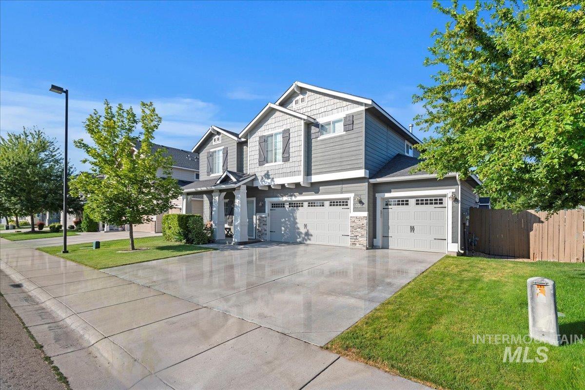 401 East Joshua Tree Drive Meridian, ID 83646 - Photo 3 of 32 Craftsman-style house featuring driveway, an attached garage, and stone siding