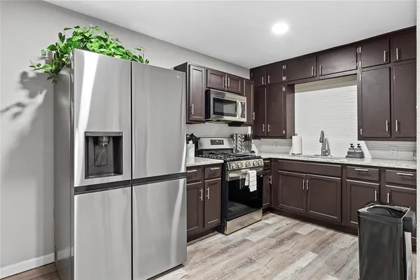 a kitchen with stainless steel appliances granite countertop a refrigerator and a sink