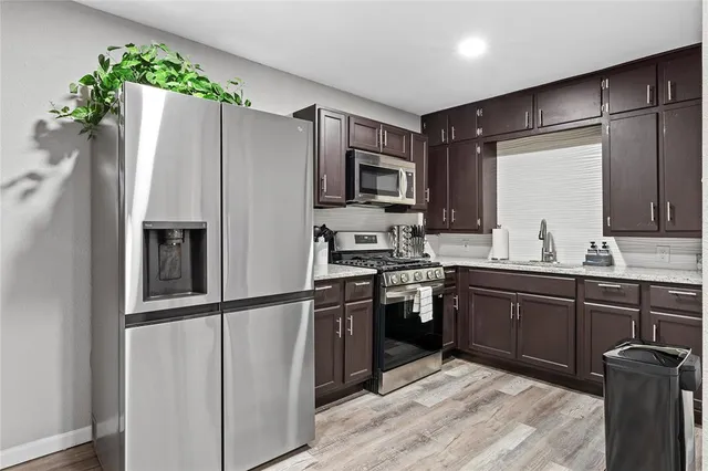 a kitchen with stainless steel appliances granite countertop a refrigerator and a sink