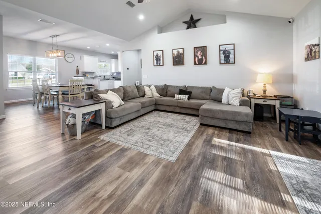 a kitchen with granite countertop a stove a refrigerator and a dining table