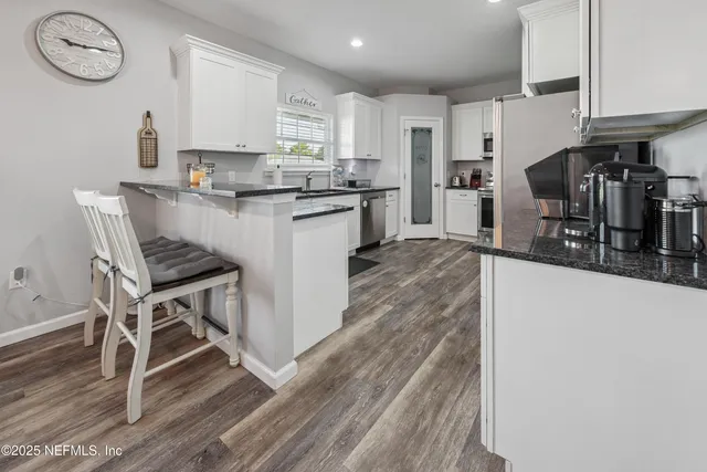 a kitchen with stainless steel appliances granite countertop a stove a refrigerator and a microwave