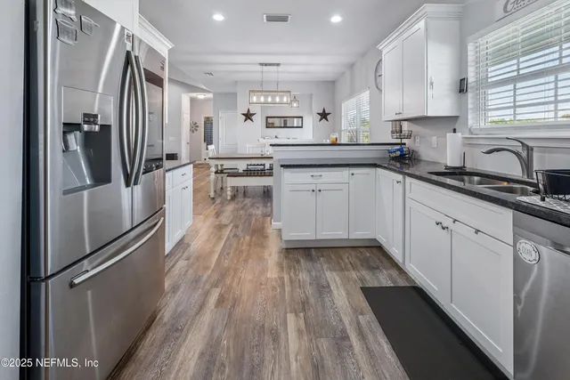 a kitchen with granite countertop white cabinets and sink