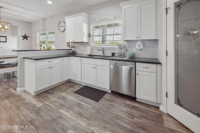 a walk in closet with wooden floor