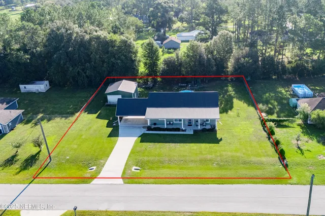 a view of a swimming pool with a yard and plants