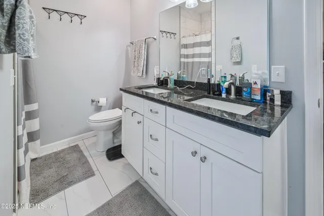 a bathroom with a granite countertop sink a mirror and shower