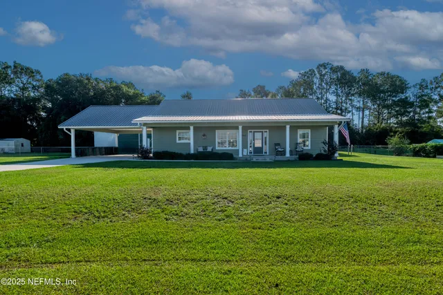 a view of house with a big yard and potted plants
