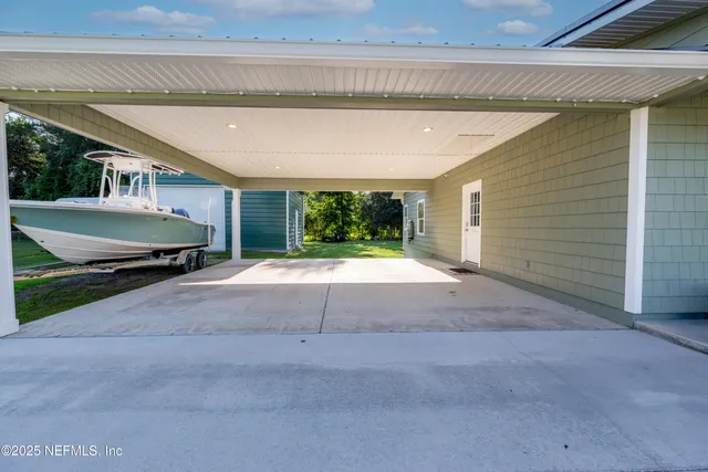 a view of a house with a big yard and large trees
