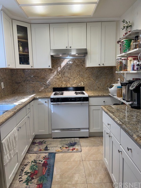 7267 Corbin Avenue, Unit B Winnetka, CA 91306 - Photo 3 of 8 a kitchen with kitchen island granite countertop a sink stove and cabinets