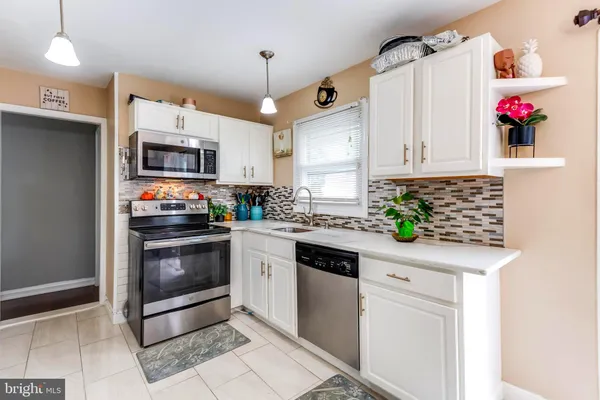 a kitchen with granite countertop a sink stainless steel appliances and cabinets