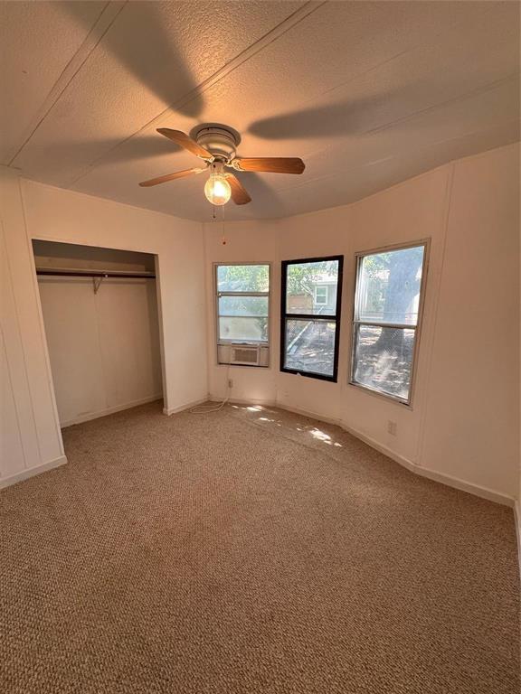 2010 Spring Court, Unit A Azle, TX 76020 - Photo 11 of 29 an empty room with windows and ceiling fan