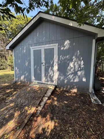 a backyard of a house with table and chairs and barbeque