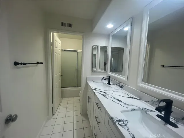 a bathroom with a double vanity sink and mirror