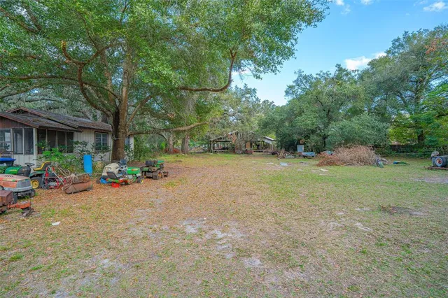 a backyard of a house with fountain and large trees
