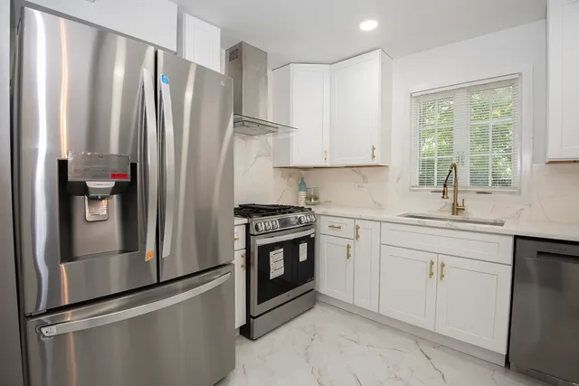 a kitchen with stainless steel appliances a refrigerator sink and cabinets